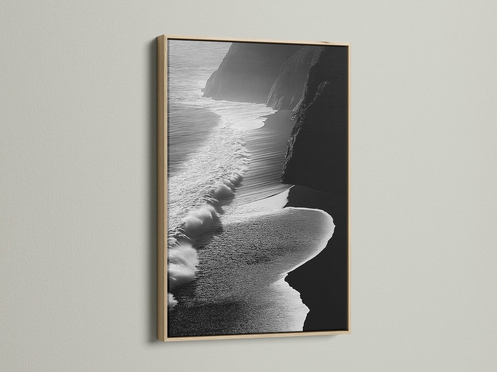 A captivating black and white aerial beach artwork graces the wall. It is framed in a natural oak. The artwork adds an elegant coastal touch to this room. The scene features ocean waves. This artwork is ideal for modern decor. It enhances living rooms and bedrooms. The oak frame complements various interior styles. Discover the beauty of ocean photography today.