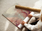 A woman rolls a fine art poster paper. Showcasing the high quality material. This Cherry Blossom Landscape Artwork is perfect for any space. The Japanese Moon Wall Art enhances your zen decor.