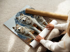 A woman is carefully rolling a fine art poster paper. She is preparing the wolf art print for display. The fine art paper enhances the details and colors of the wildlife print. Perfect for creating high-quality wall decor. This mountain landscape artwork is ideal for nature enthusiasts. The wolf pack artwork brings the beauty of the wild into your home.
