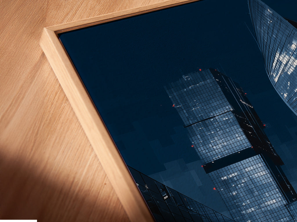 This is a close-up of a canvas print in a floating frame. The blue night cityscape art appears to float. This modern art piece is perfect for contemporary spaces. The floating frame adds a unique touch to this urban wall art.