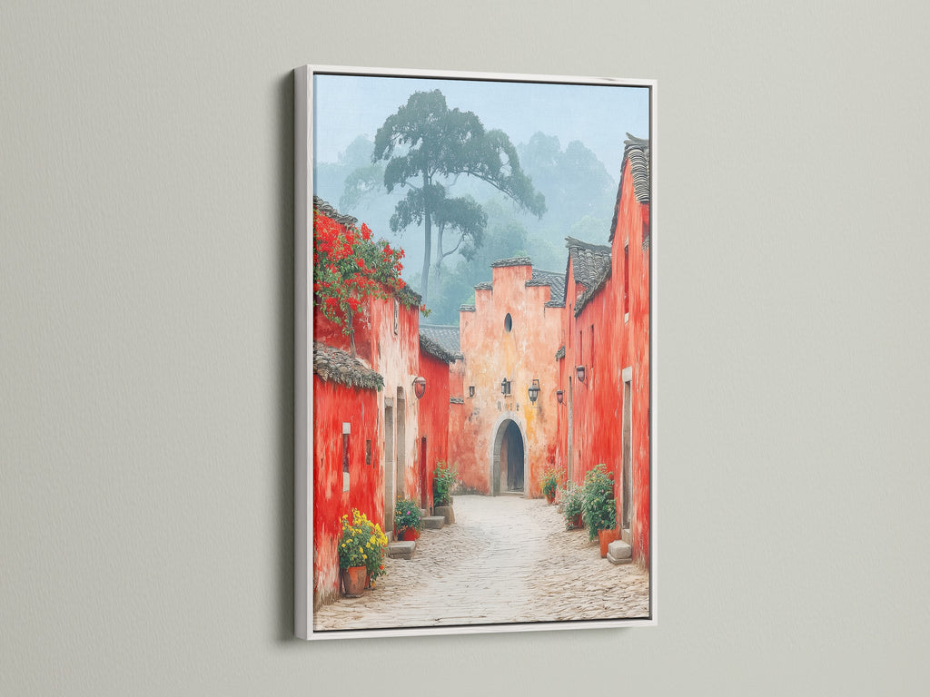 Village Street artwork with a white frame.  The white frame provides a clean contrast to the red and peach tones of this european village art. Ideal for brightening up your living room wall. This is a vintage print for any home.