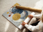 A woman carefully rolls fine art poster paper. Preparing modern abstract artwork for display. The blue and gold circle artwork will enhance any living room bedroom or office space.
