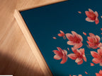 Close-up of a canvas print in a floating frame. The artwork features a cherry blossom tree with teal and pink hues. This modern framing style adds depth to your floral wall decor. Perfect for a bedroom or living room.