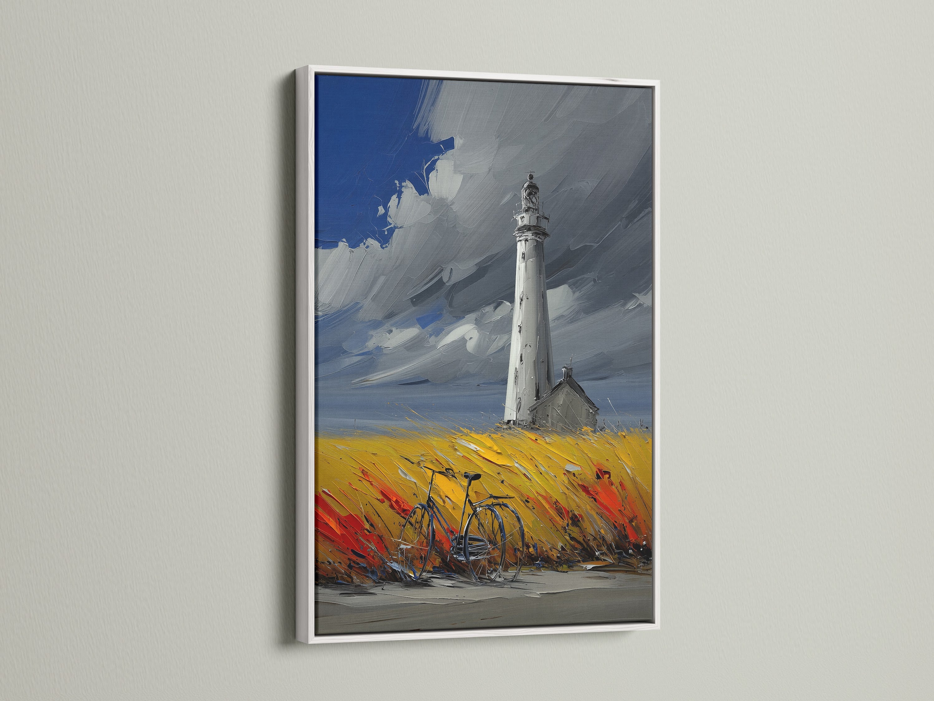 Lighthouse coastal artwork with a white frame. This seascape artwork is ideal for creating a serene atmosphere.  Great for living room wall art or bedroom wall decor. The artwork features a lighthouse in a field of yellow and red. A bicycle is parked nearby. The sky is a mix of blue and grey.
