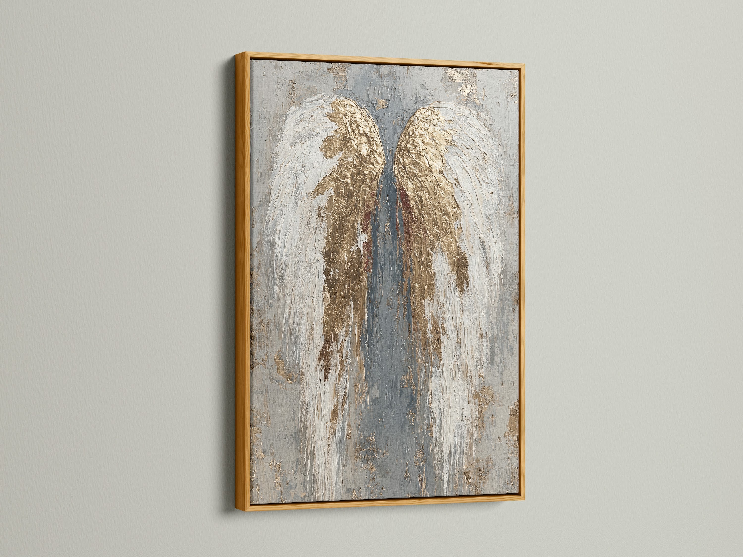The angel wings artwork is encased in a gold frame. The artwork is displayed on a white wall. The gold frame adds a luxurious and elegant aesthetic. It enhances the artwork's richness. It brings a touch of opulence to any room.