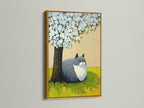 A gold frame highlights a charming cat under tree artwork. This whimsical nursery art brings a touch of spring blossom beauty. It is a perfect cat lover gift and bedroom wall decor addition. The botanical cat art fits seamlessly into contemporary minimalist styles.