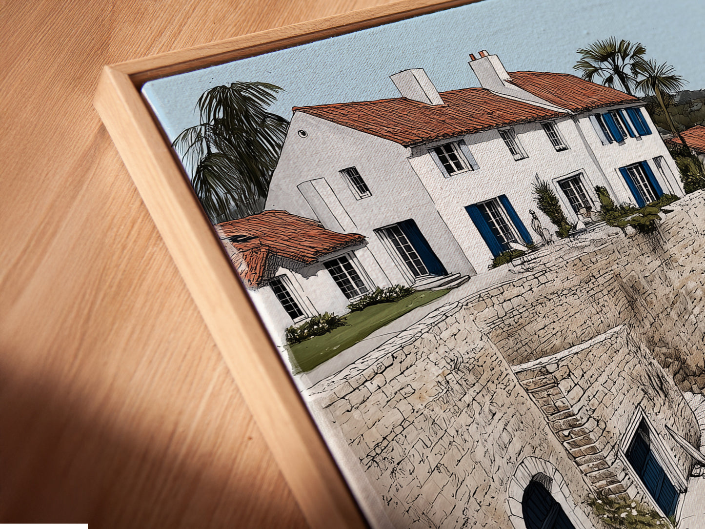 Angled close up of a Coastal Village canvas print in a floating frame. The artwork features a charming seaside scene. The floating frame adds a modern touch. The canvas print enhances the details of the coastal artwork. Perfect for adding a touch of Mediterranean charm to your home.