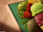 Close-up angled view of a canvas print in a floating frame. The artwork features an ice cream cone. It is surrounded by fresh fruits. The floating frame gives a modern gallery look. It enhances the visual depth. Perfect for art enthusiasts who appreciate fine details.