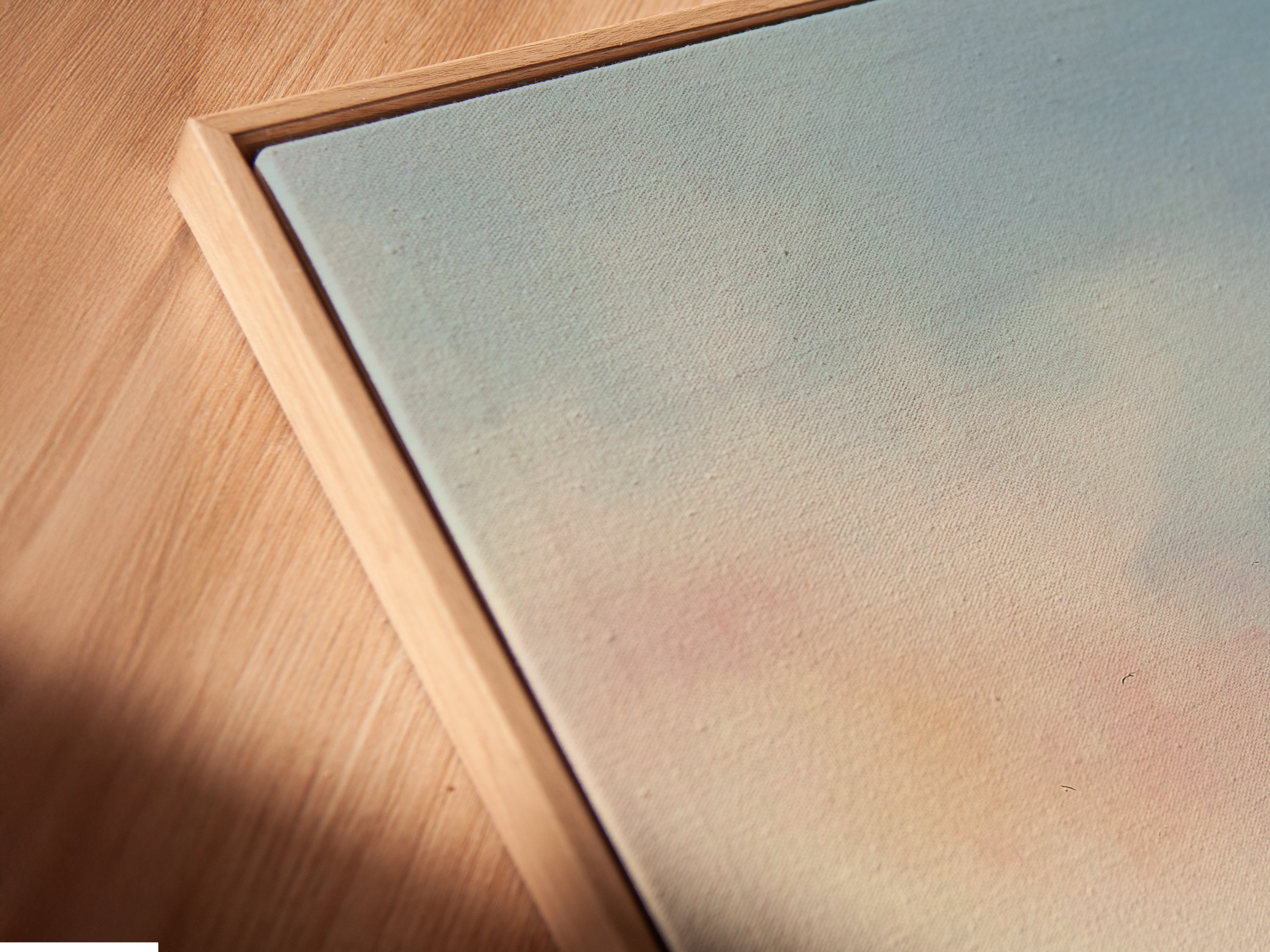 Close-up of a canvas print featuring a Cargo Ship. The artwork is displayed in a floating frame. This coastal seascape wall art offers a modern look. The minimalist maritime artwork is perfect for office wall decor. Enhance your space with this tranquil wall art.