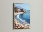 This is a coastal beach canvas art piece. The artwork is framed in a natural oak frame. The serene California seascape adds a calming touch to any space. Ideal for beach house decor or anyone seeking tranquil wall art.
