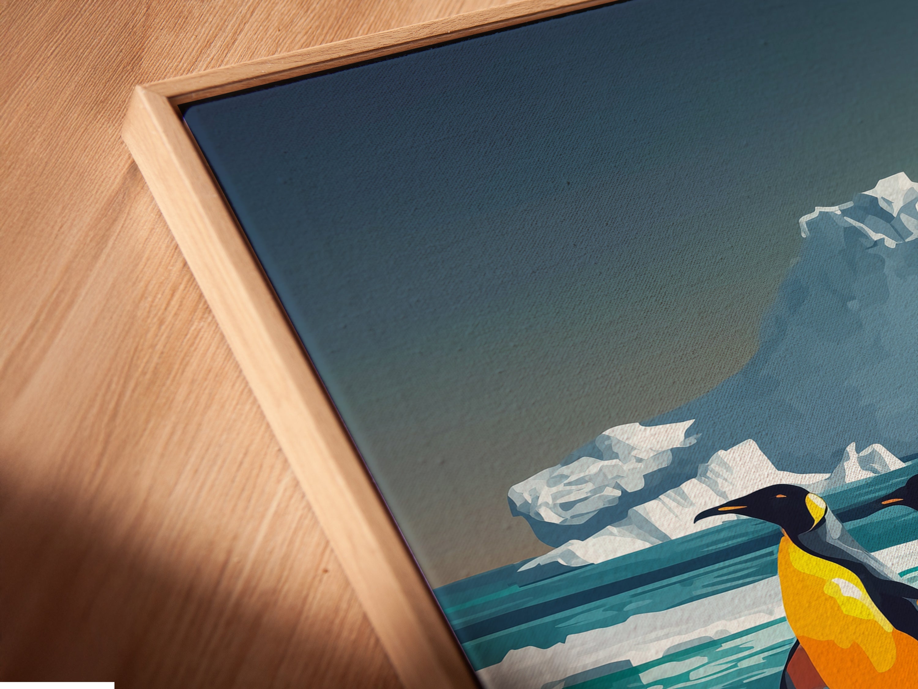 A close-up of a canvas print in a floating frame. The penguin artwork captures the beauty of arctic wildlife. This piece is perfect for adding a touch of marine life to a modern interior. This contemporary artwork is great for any room