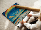 A woman is carefully rolling a fine art poster paper. This action prepares the chess skydiving artwork for display. The surreal print is perfect for those seeking unique and modern wall art for their home or office.