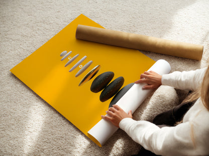 A woman carefully rolling a fine art poster paper of the Zen Stone Artwork. High-quality material ensures the artwork is protected. This ochre yellow artwork will be a beautiful addition to any room. Great for meditation.