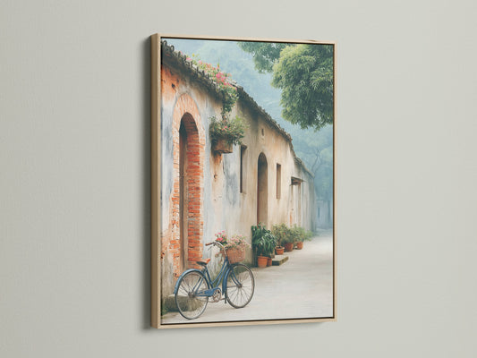 Vintage bicycle art in an oak frame. The rustic European street scene adds charm to any room. The blue bicycle with a flower basket is a focal point. This architecture artwork would look amazing in a library or cafe. Perfect for rustic wall art.