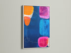 Modern Abstract Art in a White Frame. The geometric print features a navy blue background with pink orange and blue shapes. Enhance your office wall decor with this colorful wall art. This contemporary art piece brings a vibrant touch to any gallery or studio