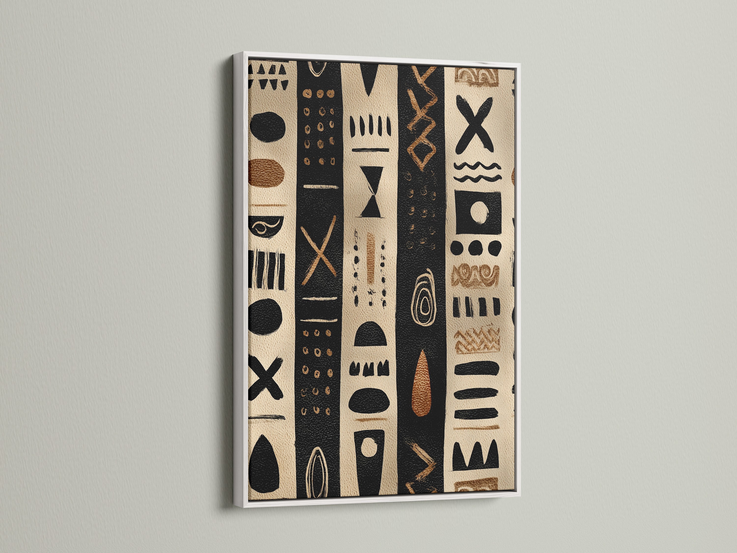 Artwork in a white frame. The artwork has black and tan stripes with tribal inspired shapes. The artwork is hanging on a white wall. The white frame is perfect for a modern home. This artwork is beautiful and unique.
