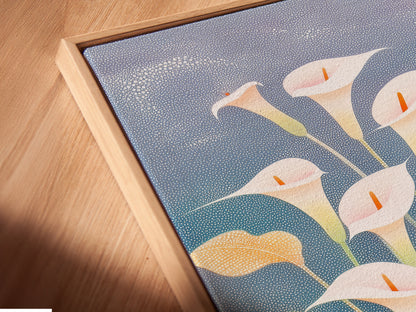 A close-up angled view shows a canvas print in a floating frame. The artwork features Calla Lilies. This is a floral botanical print. It is perfect for adding modern spring decor to a home. It's ideal for living rooms and bedrooms.