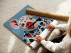 A woman is carefully rolling a fine art poster paper. The paper features a pig art design with a colorful farm animal. The fine art poster paper ensures high-quality reproduction. This whimsical artwork is perfect for adding a touch of charm to your home. It's ideal for art enthusiasts and collectors.