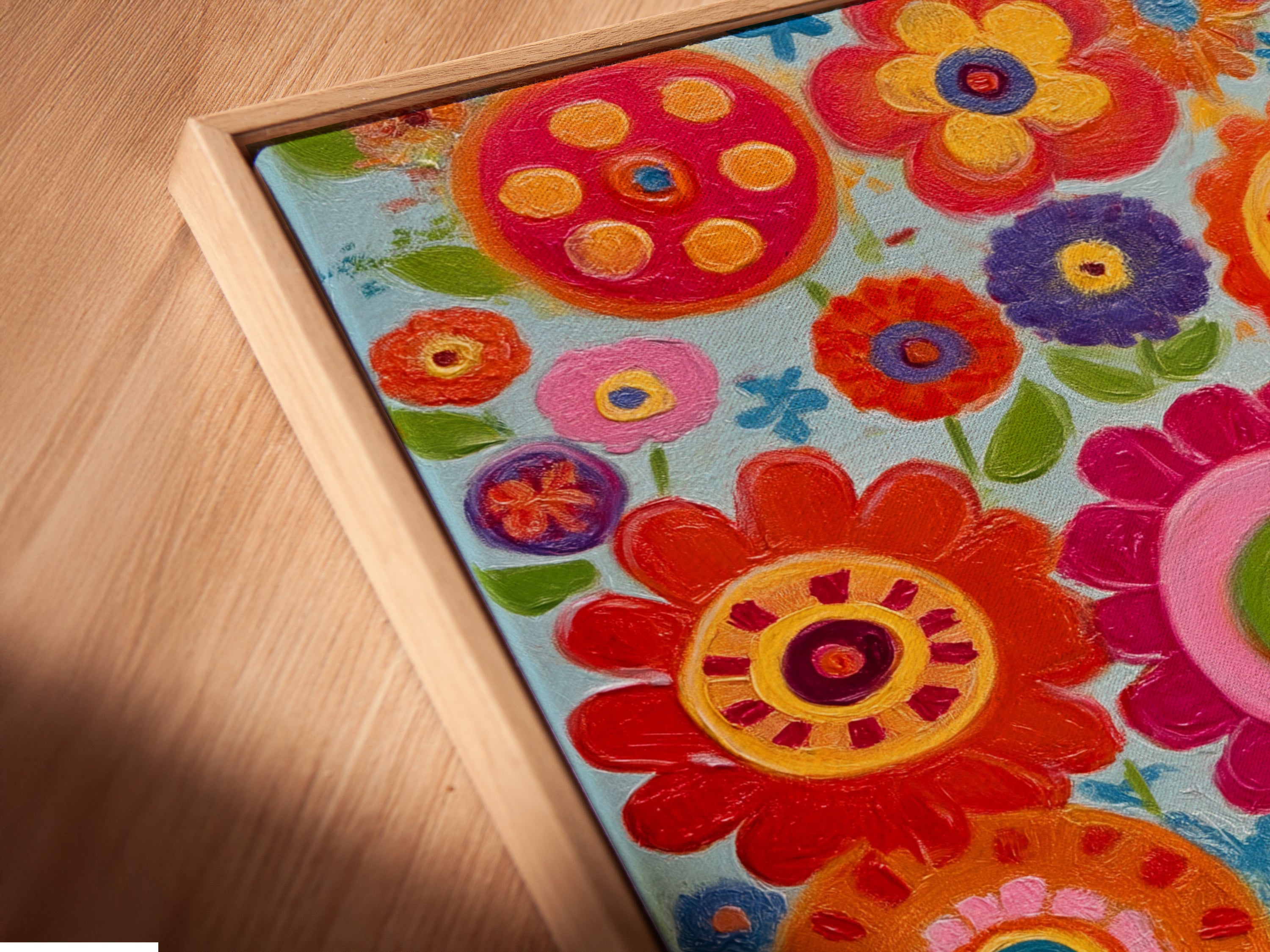 Angled close up of a canvas print in a floating frame. The colorful floral artwork pops. This whimsical botanical print is perfect for adding a touch of charm. It's a great addition to any home with flower art.