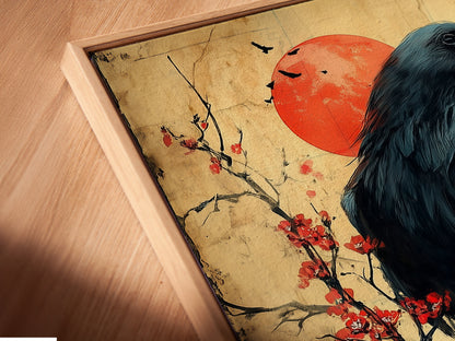 Angled close up of a raven canvas print in a floating frame. The Japanese art wall decor features a bird on a cherry blossom branch. The gothic print is a great addition to studies and libraries.