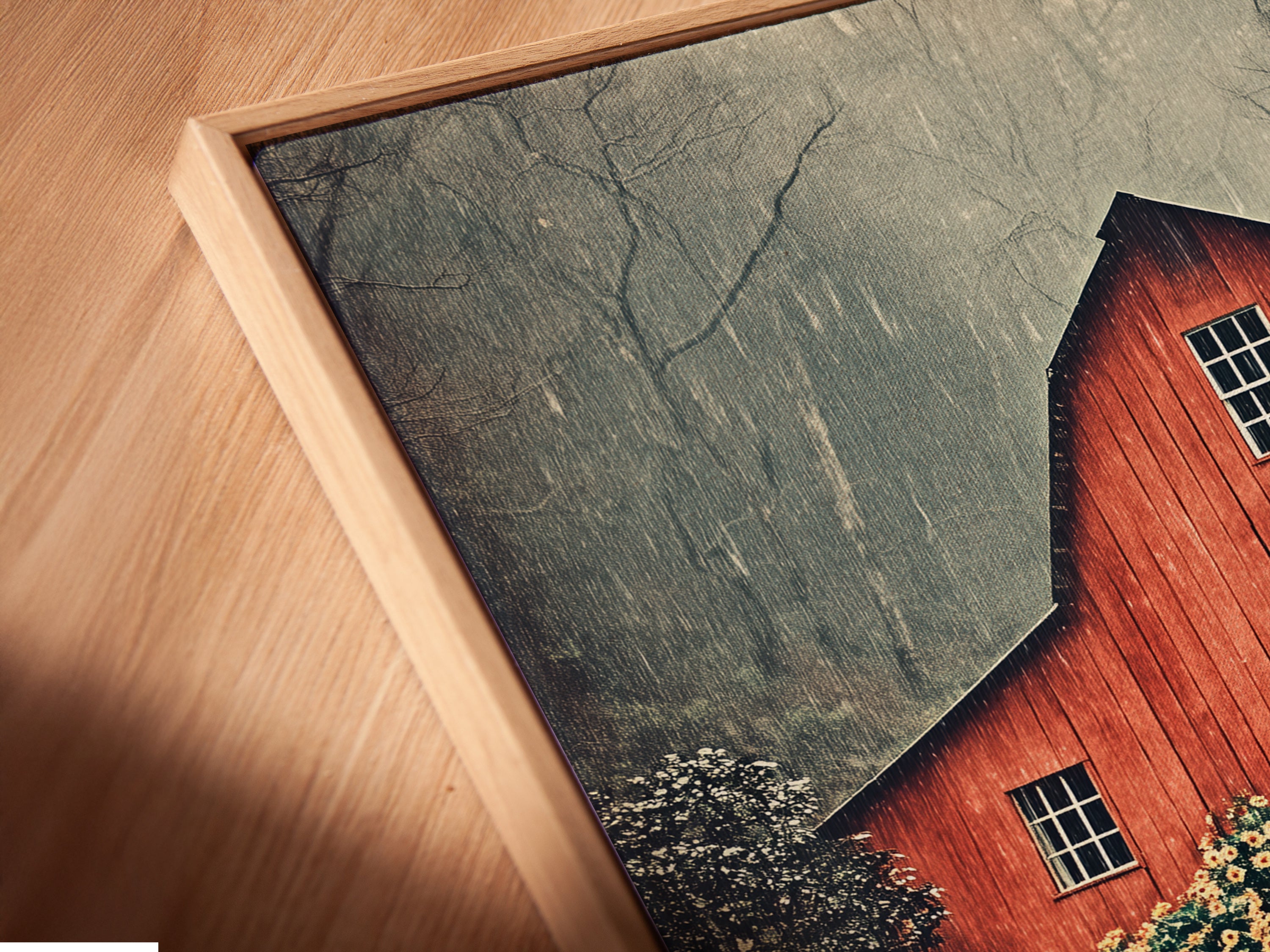 A close-up angled view shows a canvas print of the red barn artwork in a floating frame. This floating frame style adds depth and modernity. Enhance your rustic decor with this unique piece.