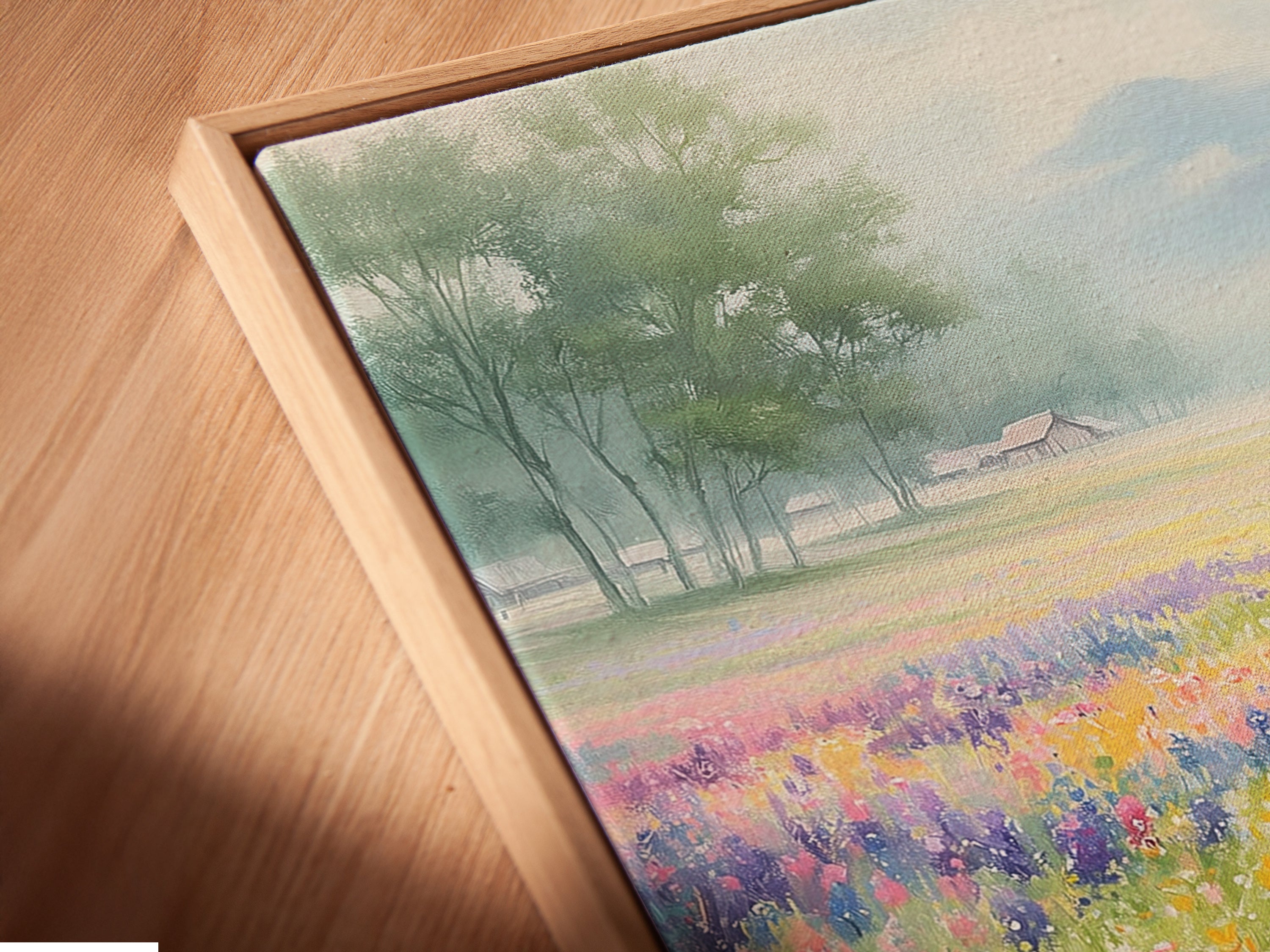 An angled close up shows a canvas print in a floating frame. The wildflower field artwork adds color and charm. Perfect for those seeking refined Nature & Landscapes Wall Art. Ideal for farmhouse country or cottage styles.