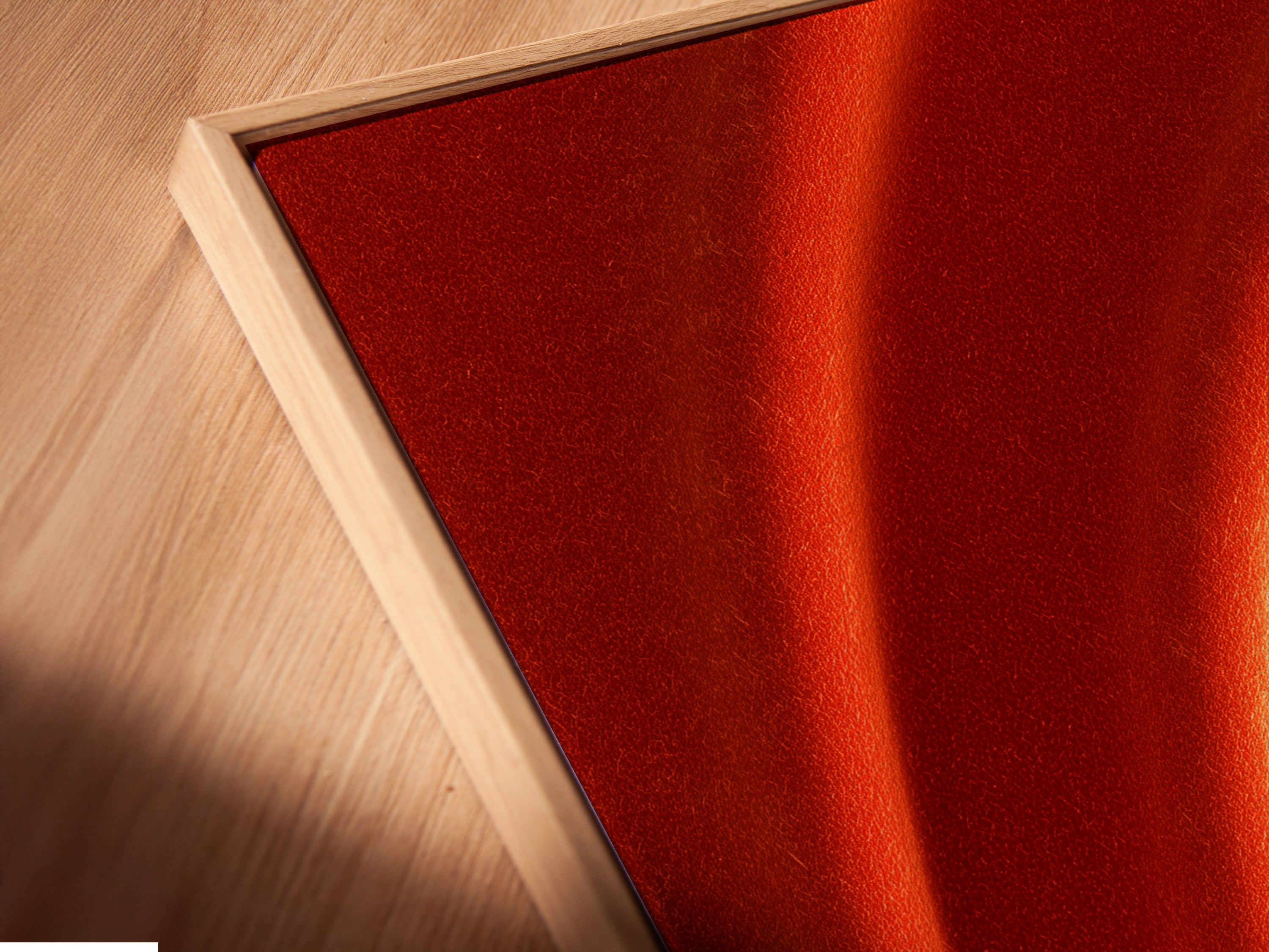 A close-up angled view of an abstract terracotta canvas print. It is displayed in a floating frame. This modern minimalist poster adds warmth to any space. Perfect for bedroom wall decor and contemporary styled spaces. Enhance your interior with unique artwork.