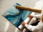 A woman is carefully rolling a fine art poster paper. The paper is high-quality ensuring a pristine finish. This poster paper is ideal for showcasing artwork. Perfect for creating stunning prints of abstract art. The smooth surface enhances the colors and details of the art.