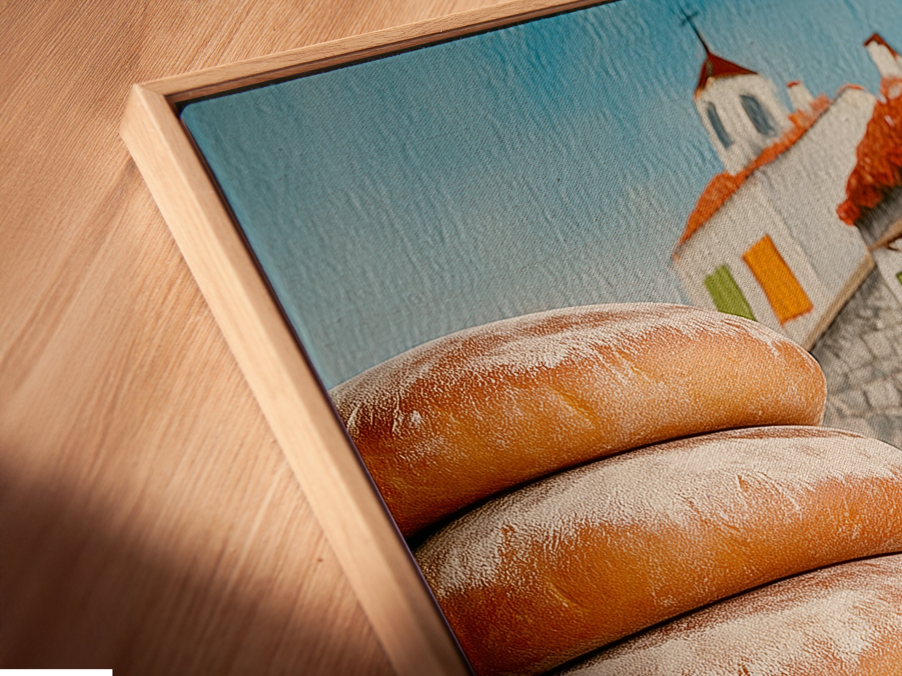 Close-up of a canvas print in a floating frame. This rustic artwork features fresh bread. It is ideal for adding charm to your kitchen or dining area. It enhances farmhouse country or French-inspired styles. The print is a delightful piece.