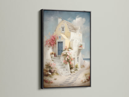 Coastal artwork in a black frame. The artwork features a Mediterranean house canvas with a blue door and floral stairway. Perfect for adding Greek island art to your vacation home decor. This sea view print enhances any space. Ideal for living room wall art.