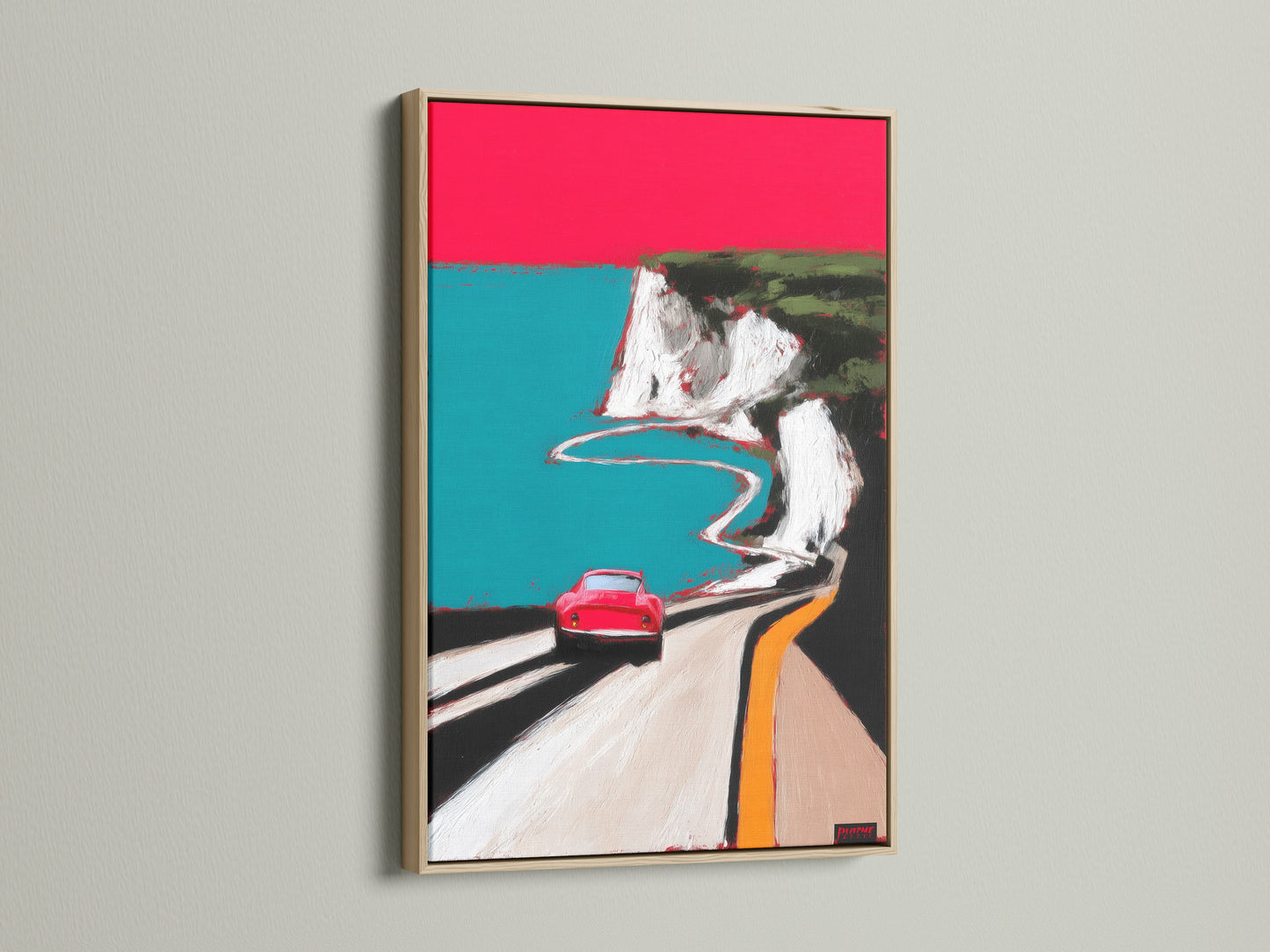 Coastal road artwork print in an oak frame. The print showcases a red car driving along a coastal road. The oak frame enhances the artwork's mid-century modern style. Ideal for adding a touch of retro charm to any room. A great choice for car art collectors.
