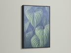 The black frame contrasts beautifully with the tropical leaf artwork. This modern botanical print adds elegance. It’s ideal as office wall art. The black frame makes the blue green decor pop. This is a stunning piece.