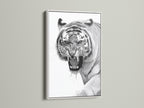 The artwork features a captivating tiger in a clean white frame. The white frame offers a modern aesthetic. The art will brighten any room. This piece adds a touch of elegance to your home. The contrast of the white frame makes the artwork pop.