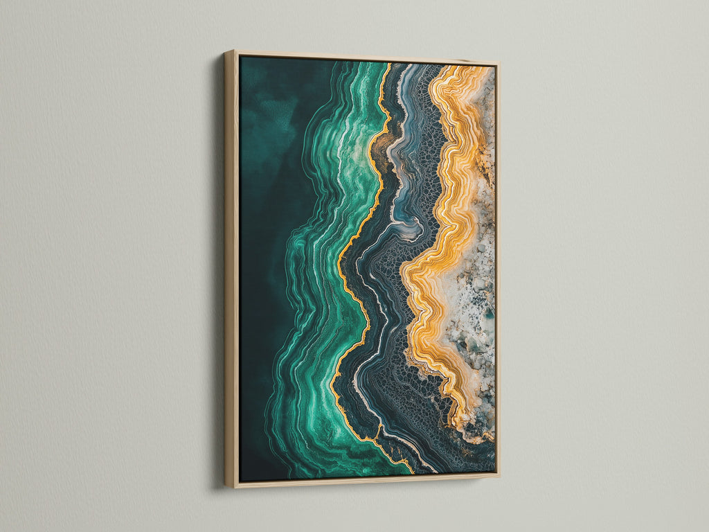 A close up of an abstract ocean art print. The emerald green teal and gold create a mesmerizing fluid artwork. An oak frame enhances the beauty of this modern abstract art. Perfect for any home or office.