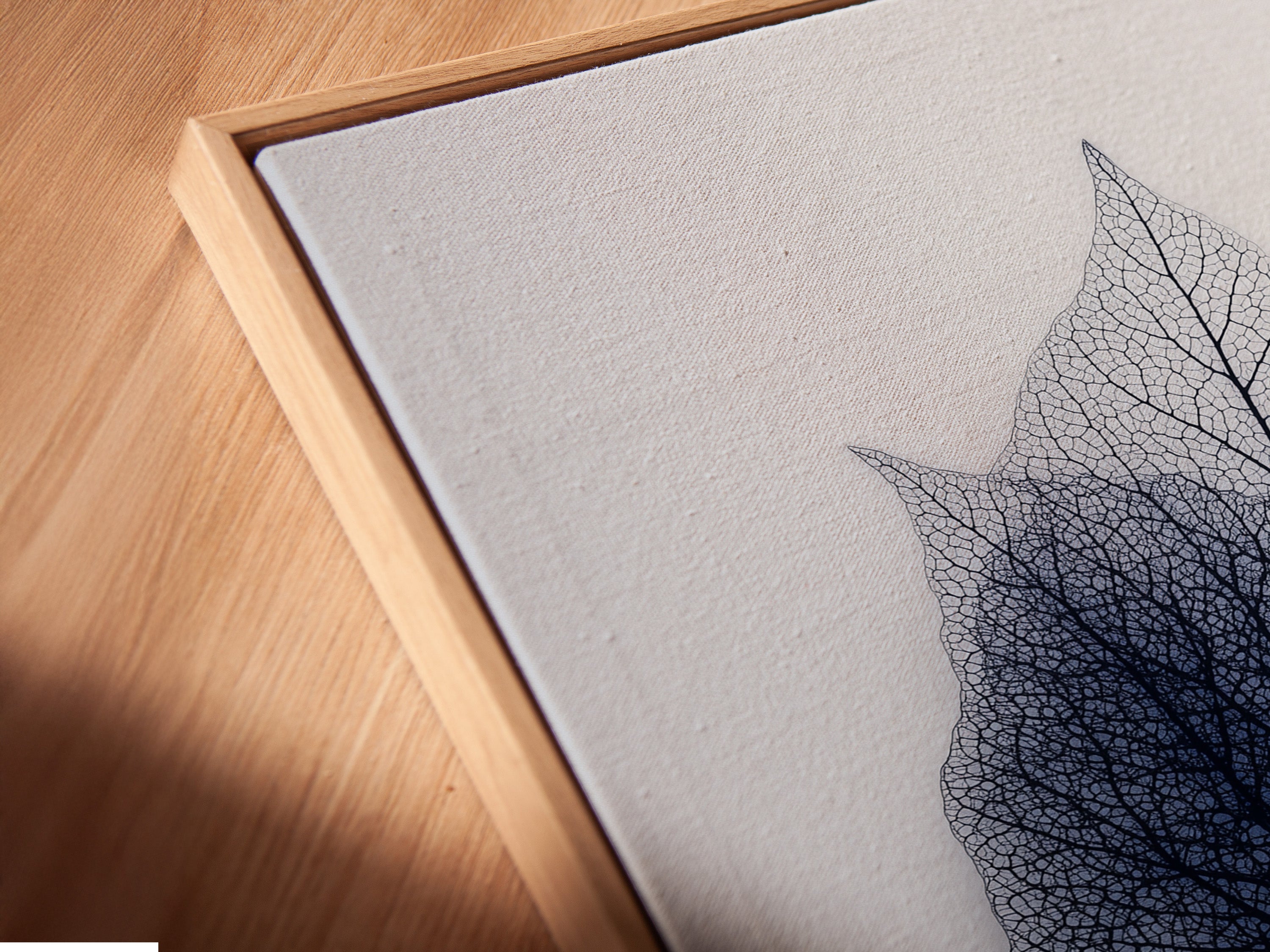 Angled close-up of leaf art in a floating frame. The floating frame gives the artwork a unique suspended look. This frame enhances the depth and dimension. It creates a modern minimalist display. Showcase your art in a floating frame.