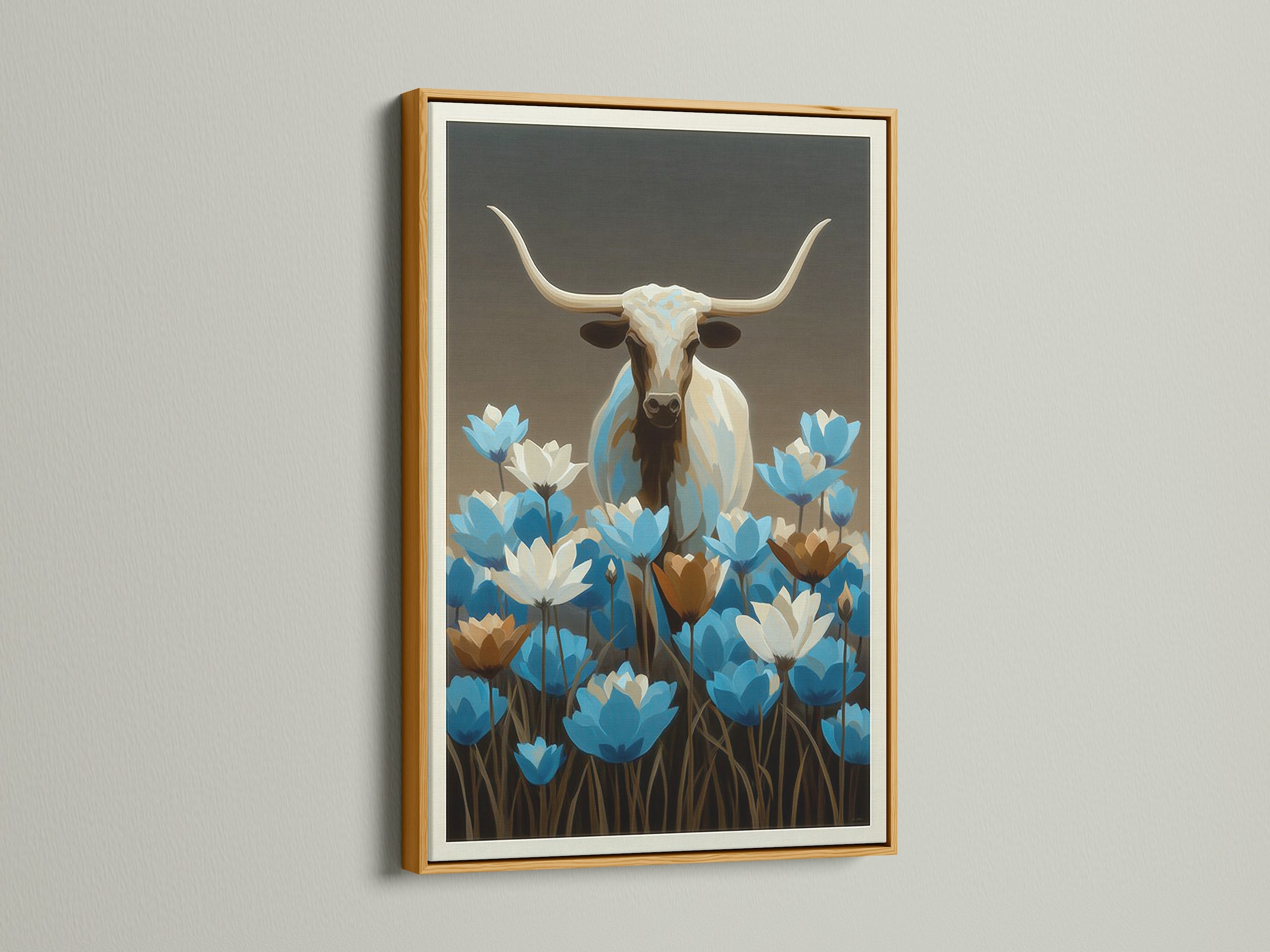 Longhorn bull artwork with blue wildflowers in a gold frame. Western wall decor is perfect for any room. This bull canvas print is ideal for modern farmhouse decor. The blue floral art piece is a great addition to your home.