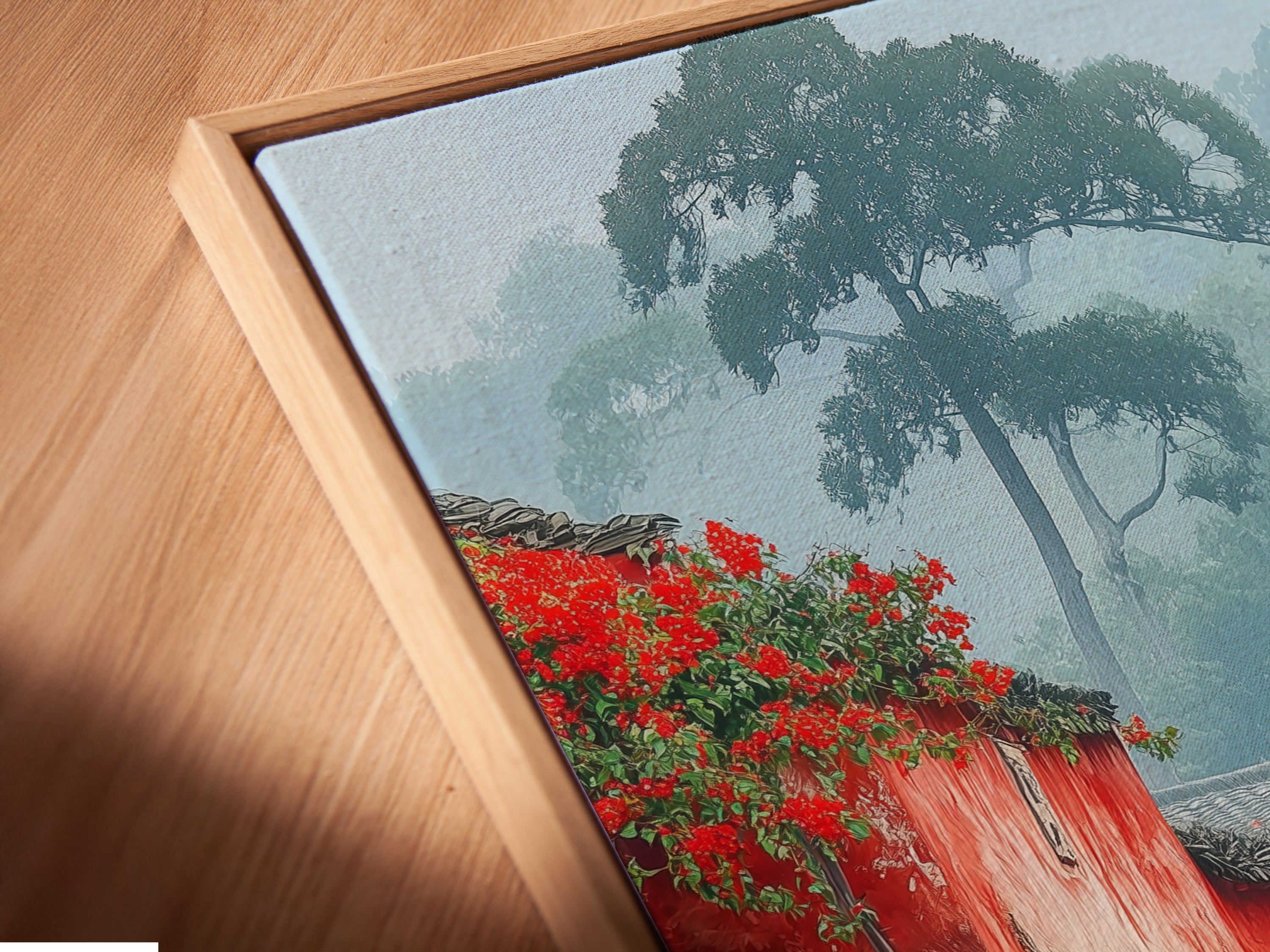 Close up of a canvas print of a Village Street art piece in a floating frame. The floating frame gives the artwork a contemporary look. Perfect for showcasing this vintage style architecture poster. The red and peach colors are vibrant.