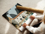 A woman is carefully rolling a fine art poster paper. The paper showcases coastal villa artwork. She is preparing it for shipping or framing. This fine art poster paper captures the essence of the Mediterranean sea wall art. Perfect for your home.