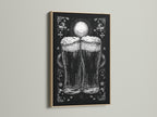 A framed artwork is on display. The art is in an oak frame. The artwork features a monochromatic illustration of two beer glasses. The beer glasses are the focal point.  The print adds a touch of elegance to any room. Perfect for home bars or kitchen spaces.