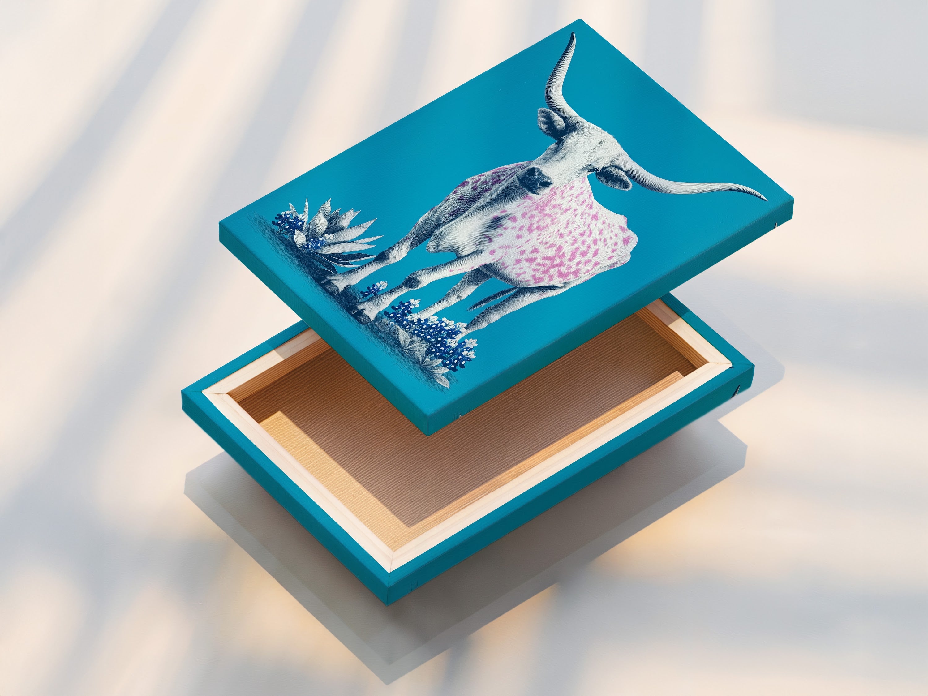 This is a stretched canvas print of longhorn cow artwork. The artwork features a turquoise background. A cow with pink spots stands out. The stretched canvas provides a gallery-ready look. It is perfect for easy wall mounting.