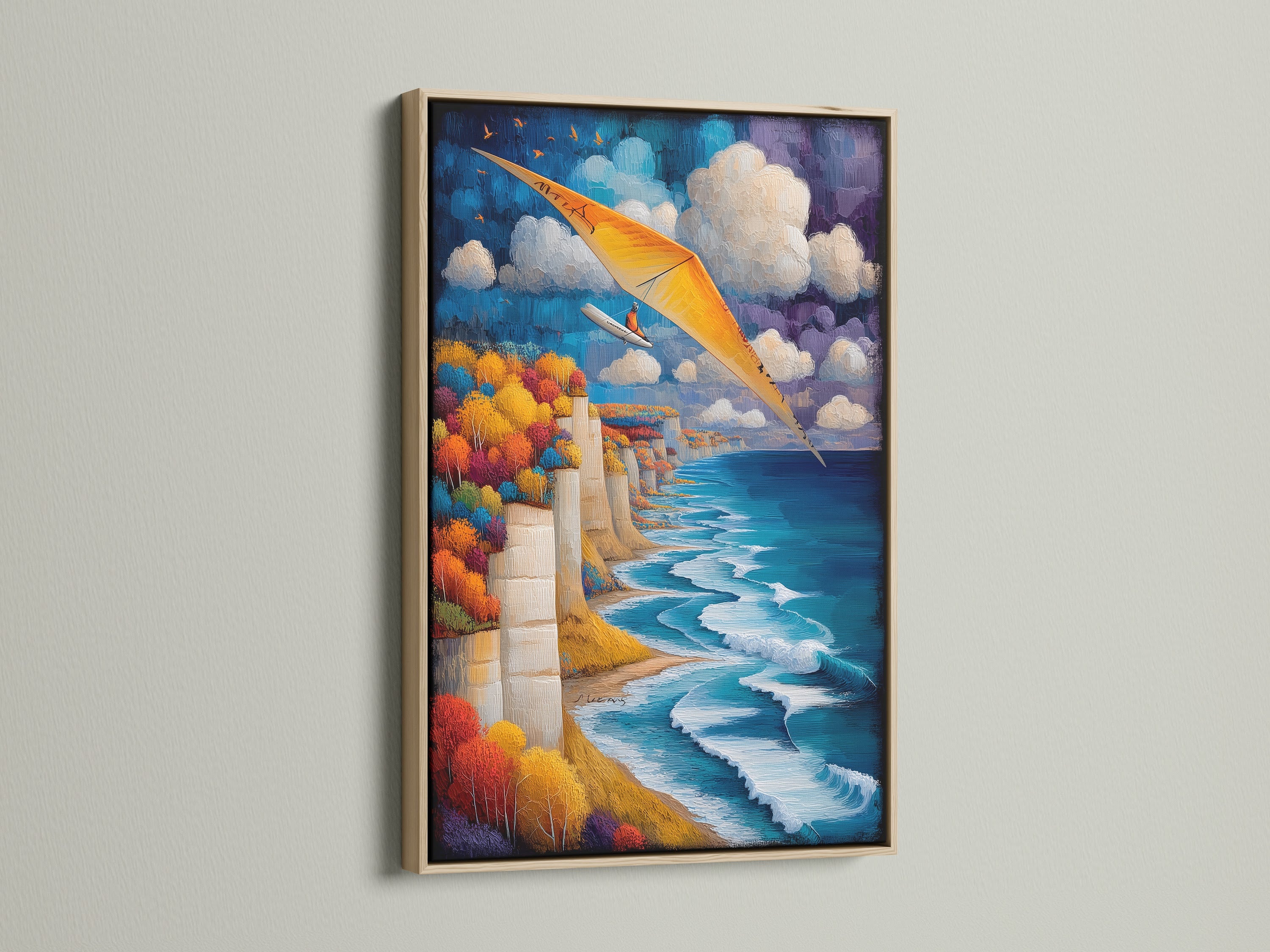 Hang gliding artwork in an oak frame. Aviation wall art brings the coast to your home. The art shows a cliffside scenery with a blue ocean and orange hang glider. A perfect adventure print for travel themed spaces. Add coastal landscape to your decor.