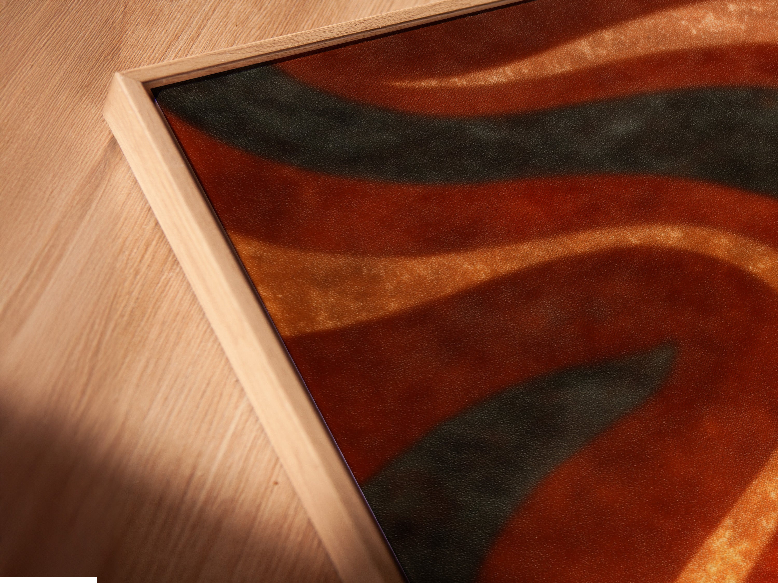 A close-up angled view of a canvas print in a floating frame. The abstract wave art features earthy rust orange and sage green colors. Perfect for adding a bohemian and retro touch to your living room bedroom or office.