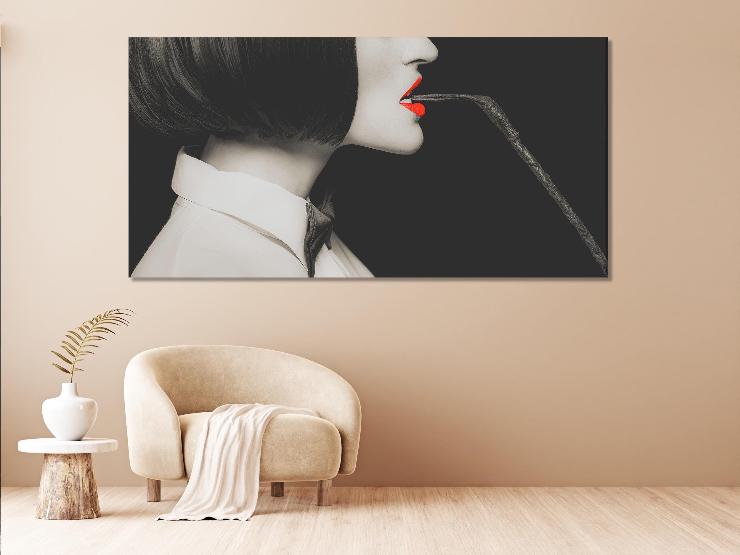 Lifestyle mockup: Bold Red Lips & Whip canvas above a sofa with neutral textiles and brass accents.