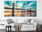 Dramatic metropolitan panorama presented as a canvas print, highlighting skyscrapers and a sweeping bridge in vivid sunset hues.