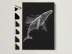 Black and white whale artwork in a brown frame is displayed on a wall. This contemporary piece adds minimalist charm to any space. Explore framing options for your marine life art. Find the perfect frame to complement your whale artwork. Consider oak white black or gold options.