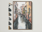 Venice Canal artwork in a brown frame on a white wall. Options for frame colors are presented on the side. This Italian watercolor wall art adds European charm to any room. Perfect for homeowners and interior decorators.