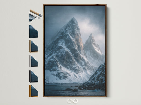Brown frame displays snowy mountain peaks artwork. This coastal mountain range wall art brings a moody landscape to your office decor. Explore all frame options for this serene mountain canvas.