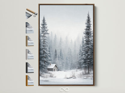 Winter Forest artwork framed in a brown frame. The artwork depicts snow-covered pine trees. A cozy cabin sits nestled in the winter landscape. Frame options are displayed on the side. Perfect wall art for rustic and cozy decor styles.