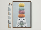 Whimsical seal artwork with colorful stacked macarons on its head. The art is framed in a brown frame. See available frame options. This playful animal art is perfect for a kids room or nursery. Add a touch of quirky charm to your home decor with this delightful seal canvas print.