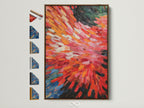 A vibrant abstract burst artwork in a brown frame is displayed. The frame options are visible on the side. The painting features dynamic brushstrokes in red and orange hues. It adds a modern touch to any room. Consider this colorful wall decor for your home or office.